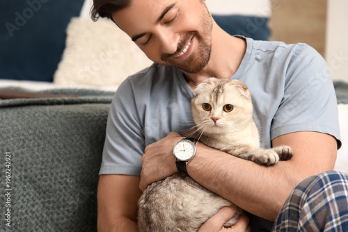 Young man playing with cute...