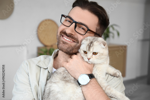 Young man holding cute Scot...
