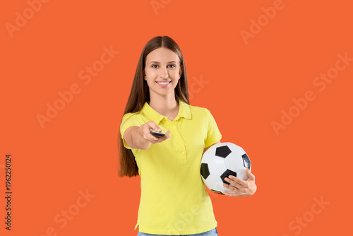 Young woman with TV remote ...