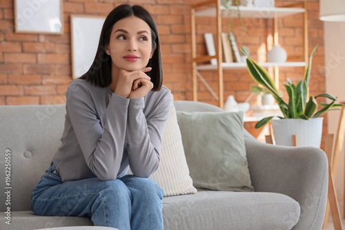 Thoughtful young woman sitt...