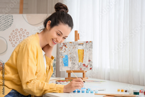 Young woman painting by num...