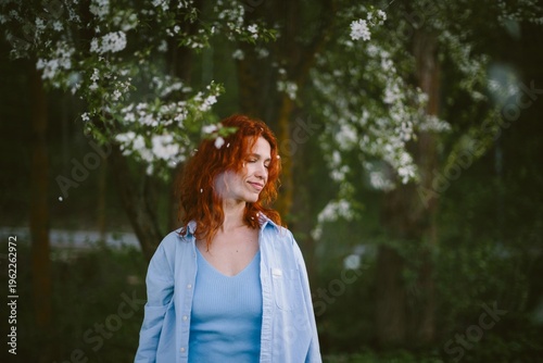 Photos Woman enjoying spring with falling flower petals