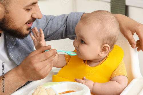 Father feeding his little b...