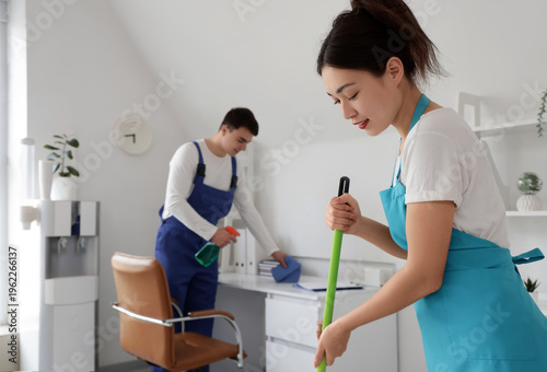 Female Asian janitor moppin...