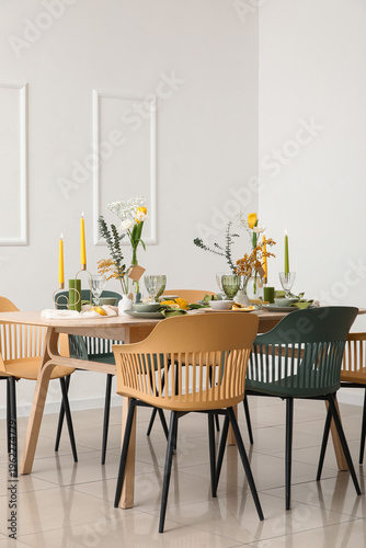 Table setting with spring flowers  near light wall in room
