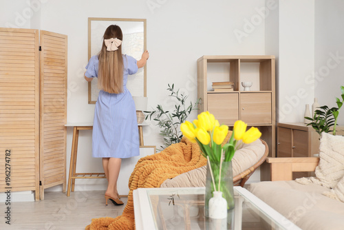 Young woman hanging blank f...