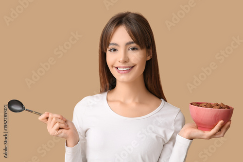 Young woman holding spoon a...