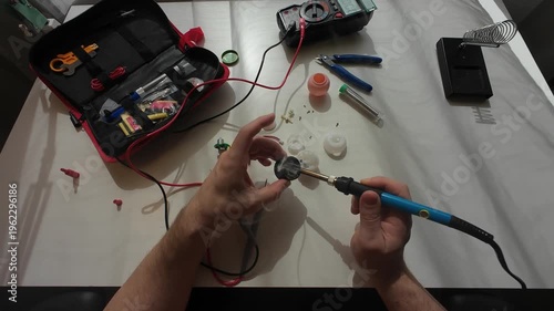 4K Electronics Repair and Soldering Close-Up, DIY Technician Working with Circuit Board, Multimeter and Soldering Iron on Workbench