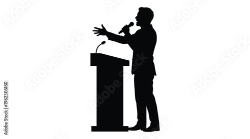 A speaker giving a presentation at a podium captured in dark silhouette