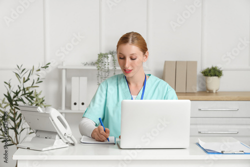 Happy female doctor with la...