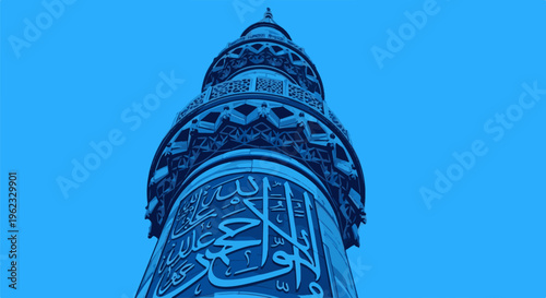 Close up of Islamic calligraphy on a blue minaret against a clear blue sky
