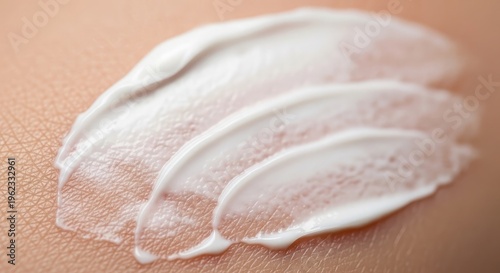 Close up of white cream or lotion swatches on a skin tone background for cosmetic product demonstration