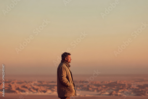 swimming coach stands against expansive ocean horizon radiating happiness