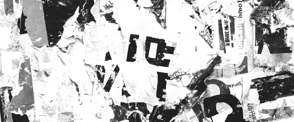 Fototapeta premium Torn black and white paper posters with text fragments on a wall