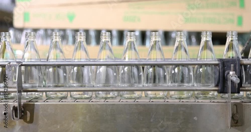 Empthy bottles on a conveyor belt in bottling process at a factory	
