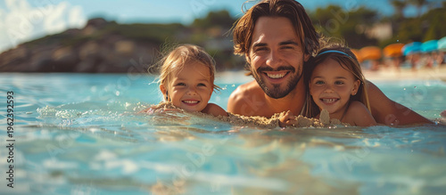 Wallpaper Mural Happy family enjoying a sunny beach day, father and two daughters playing in the shallows. Torontodigital.ca