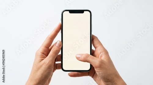 Hands holding smartphone with blank screen on light background