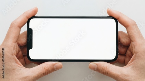 Hands holding smartphone with blank screen in horizontal orientation