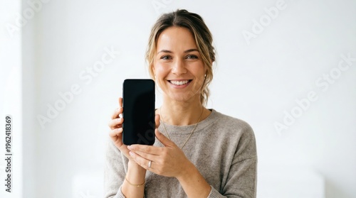 Woman showing smartphone with blank screen portrait