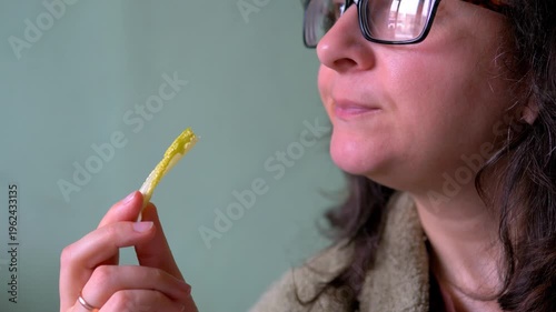 Woman Holding and Eating Single Fresh Romaine Lettuce Leaf Against Green Background — Lactuca sativa Cos Lettuce, Healthy Eating, Fresh Produce and Plant-Based Food Concept