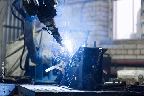 Close-up of automated robotic welding with sparks and smoke