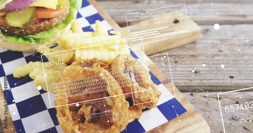 Camera panning aligning HUD overlay as burger fries onion-rings resting on wood board for food ad
