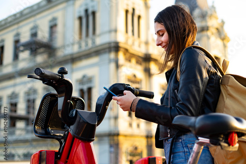 Woman renting a bicycle in the city. Electric bicycles. Rent a bike.