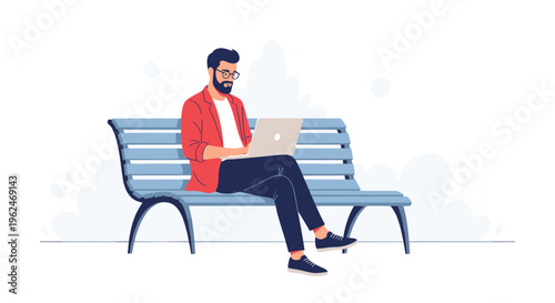 Young bearded man wearing glasses and a red jacket sitting on a park bench and working intently on his silver laptop for remote work concepts.