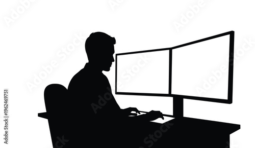 Silhouette of a person sitting in front of a computer with dual monitors