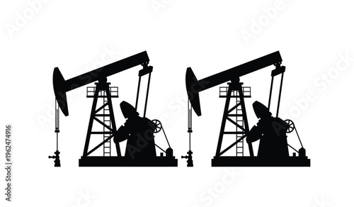 Silhouette of two oil pump jacks in operation at night