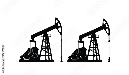 Silhouette of two oil pump jacks in operation at a petroleum extraction site