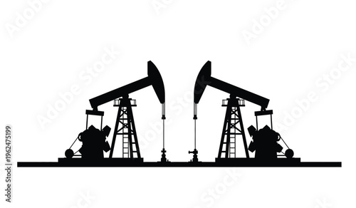Silhouette of two oil pump jacks in operation at a drilling site