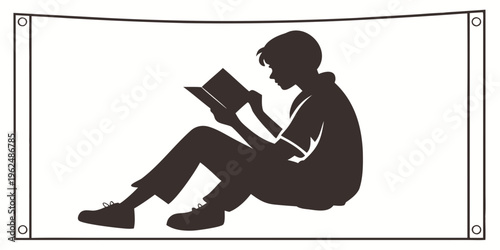 A child sitting on the floor, engrossed in reading a book.