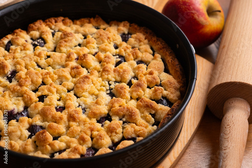 Foto Delicious homemade cherry crumble pie with fresh mint garnish on a wooden board