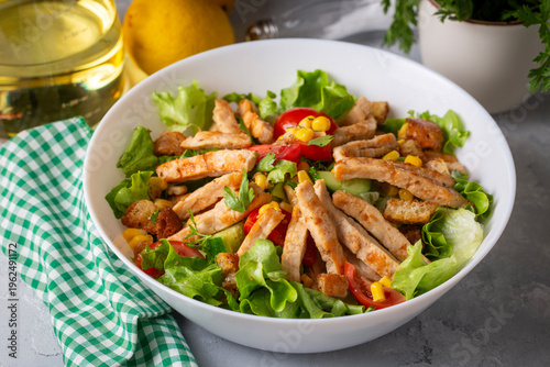  Fresh Caesar Salad with Grilled Chicken Strips, Croutons and Corn in a White Bowl