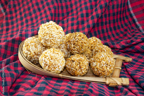 Bengali Traditional Puffed Rice Balls is a sweet made using puffed rice mixed with jaggery, Murmura Laddoo, Churmura Laddoo or Pori Urundai. flattened rice sweet ball or Chirar moa on bamboo tray.