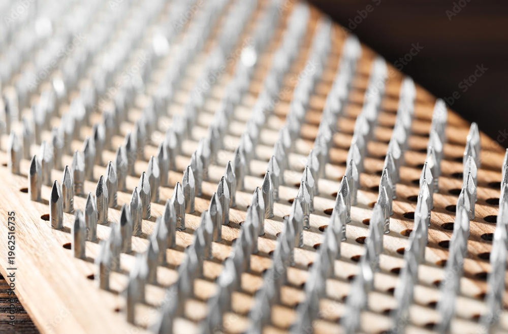 Fototapeta premium Nail standing practice. Sadhu board on brown background, closeup