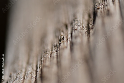 A blurred, diagonal view to an old peace of wood. A weathered wooden structure.