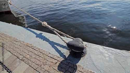 Rope is tied to a buoy in the water. The rope is tied to a buoy that is attached to a dock