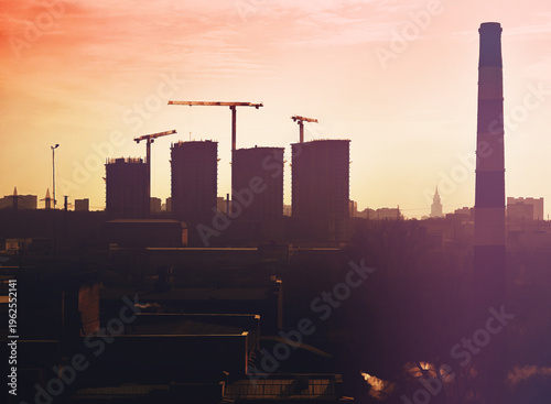 Sunset urban construction with multiple cranes illustration