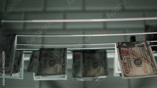 Illegal dirty grey money drying on a drying rack in the bathroom. Money laundering for illegal business in criminal world. Dollar bills in storage, anonymity and illegality