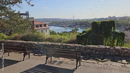 Park with two benches and a view of a river. The benches are empty. Scene is peaceful and relaxing in Belgrade