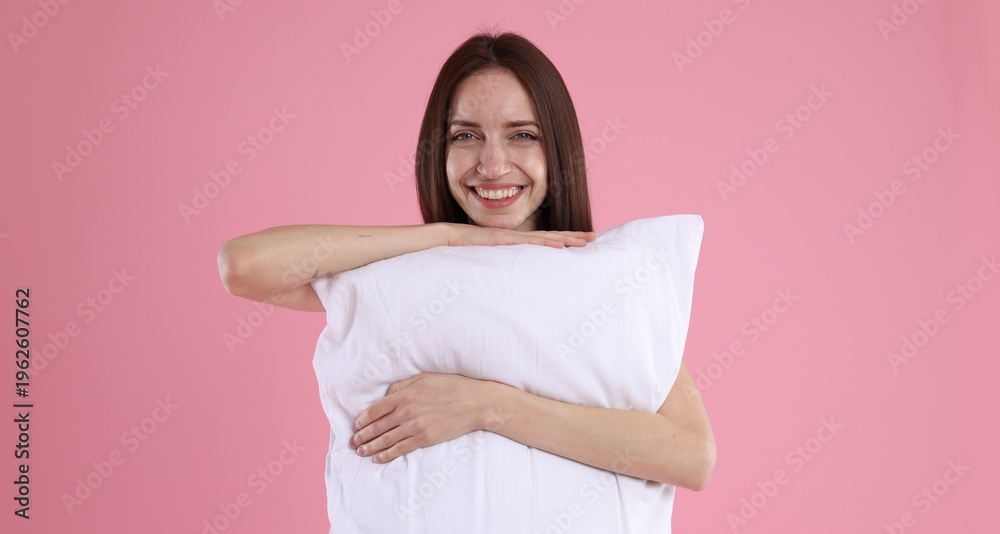 Fototapeta premium Beautiful woman with pillow on pink background