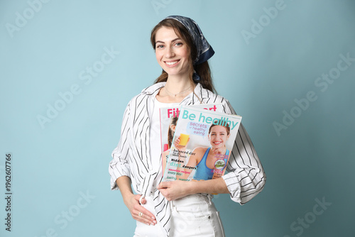 Woman with magazines on light blue background