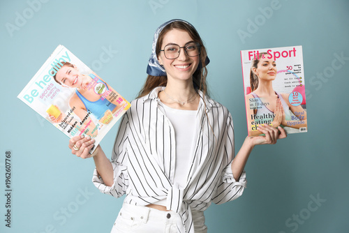 Woman with magazines on light blue background