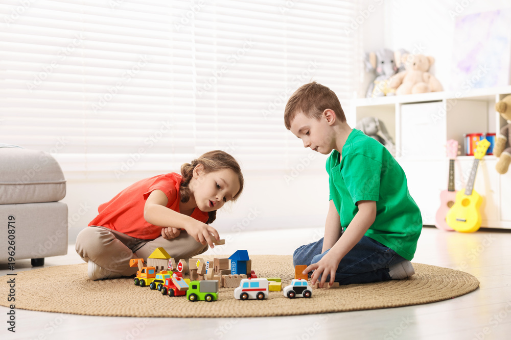Naklejka premium Cute little kids playing with toys on floor indoors