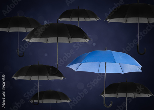 Canvastavla Blue umbrella among black ones against dark background