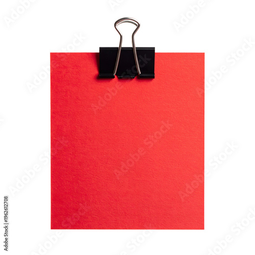 Bright red square piece of textured paper securely fastened to the top edge by a black metal binder clip  