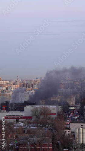Thick smoke rising from building fire in urban city, emergency situation and environmental pollution concept