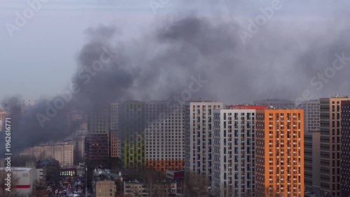 Thick smoke rising over residential buildings with emergency vehicles on scene, urban fire incident and city emergency response